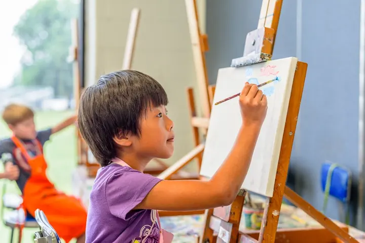 Child painting at an easel